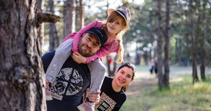 A joyful family enjoying a playful day in a sunlit forest park, capturing the essence of togetherness.