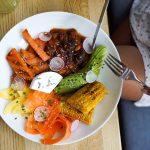 Colorful vegetarian meal with avocado, beans, and corn served on a wooden table. Ideal for healthy lifestyle visuals.