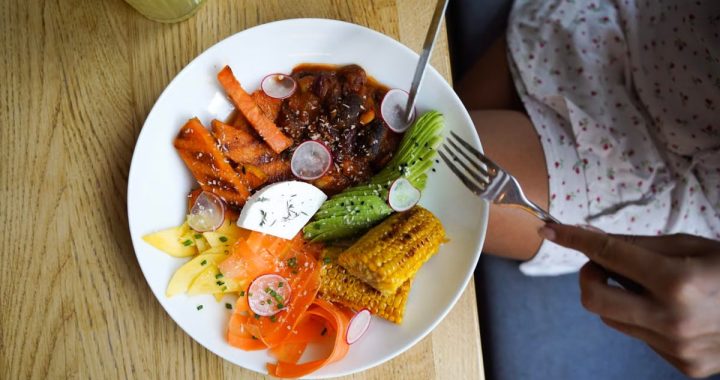 Colorful vegetarian meal with avocado, beans, and corn served on a wooden table. Ideal for healthy lifestyle visuals.